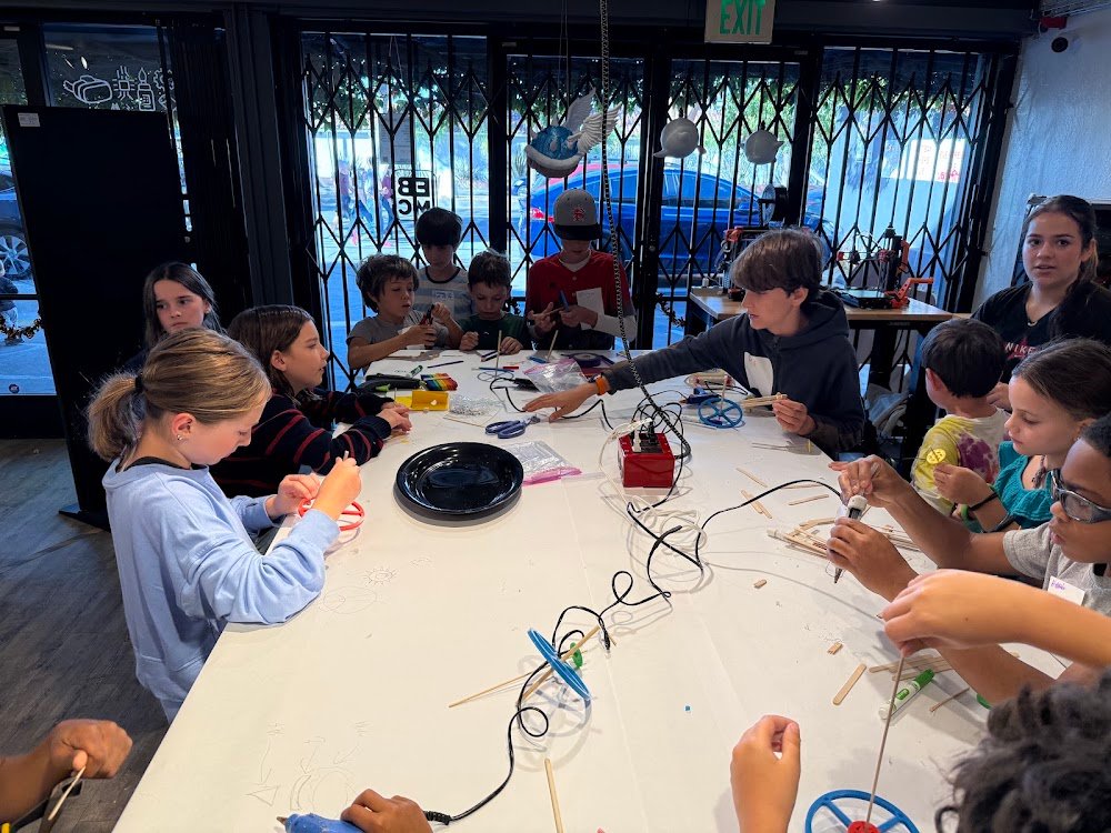 Kids building spinning tops around a long table during Battle Tops